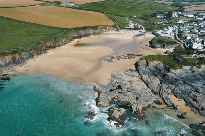 A sandy beach with surrounding rocky headland and a small town