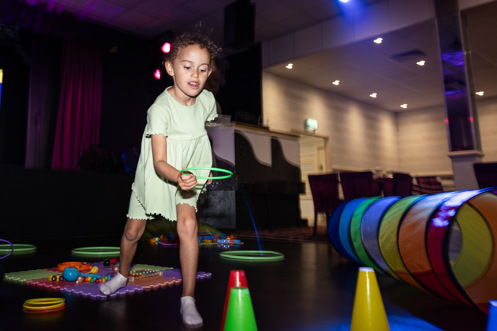 A young girl playing with various soft play toys