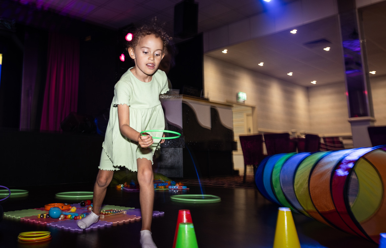 A young girl playing with various soft play toys