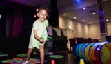 A young girl playing with various soft play toys