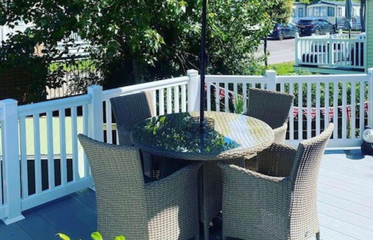 External of a caravan on pitch with decking and outdoor furniture