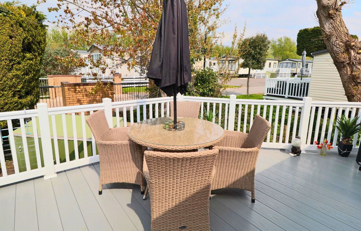 External of a caravan on pitch with decking and outdoor furniture