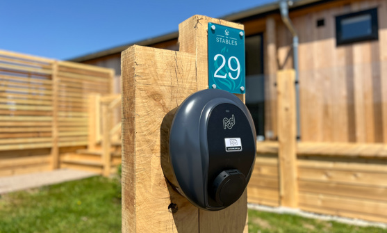 External of a luxury lodge with decking and an EV charging point