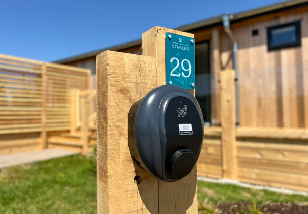 External of a luxury lodge with decking and an EV charging point