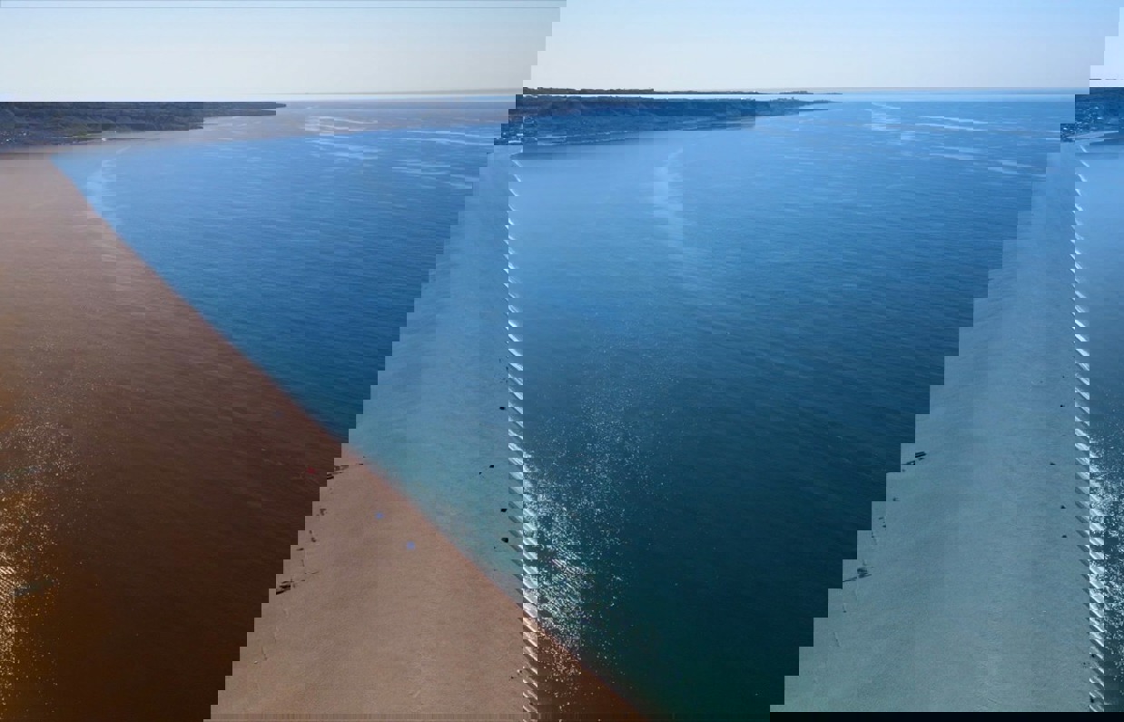 Aerial view of a stretch of Chesil Beach looking out towards the blue sea and Portland