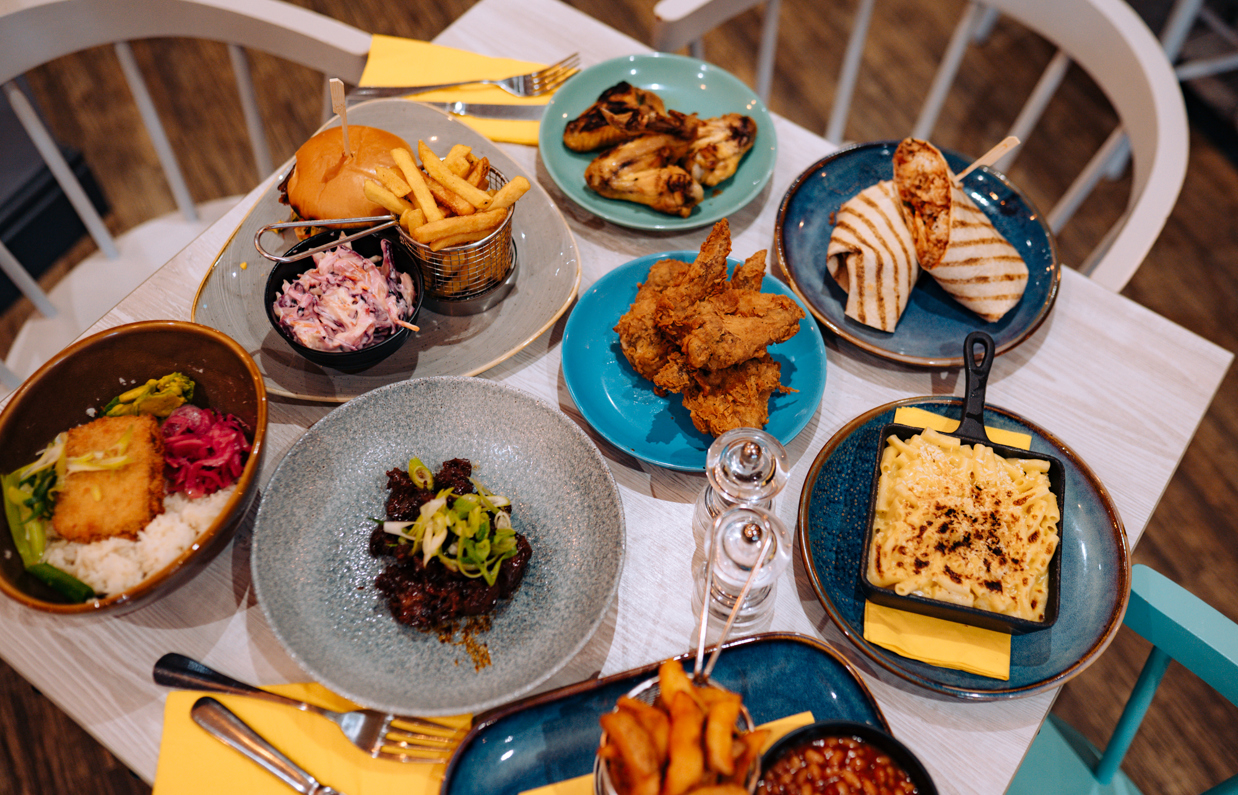 A selection of chicken, pasta, veggie and potato dishes at a table taken from above