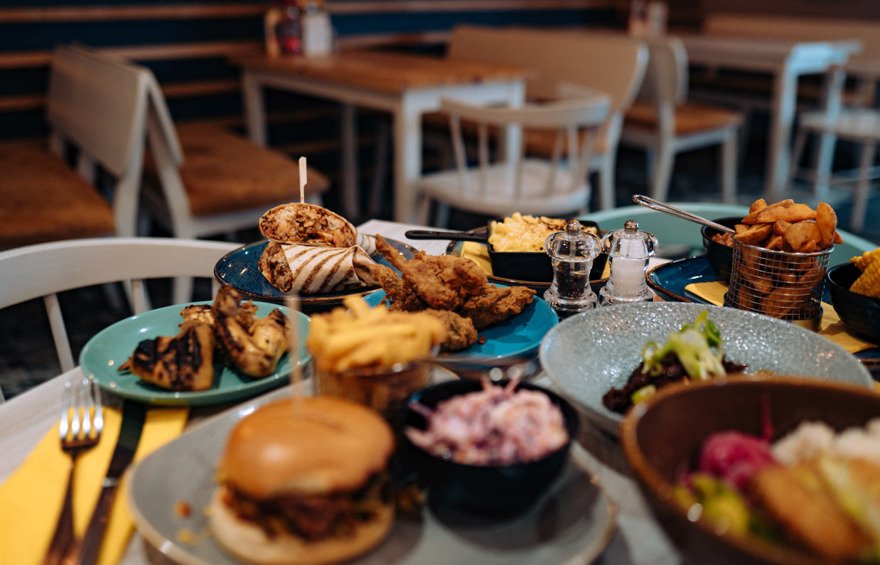 A selection of chicken, pasta, veggie and potato dishes on a table 