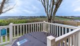External of a lodge on pitch with decking and a hot tub with countryside views
