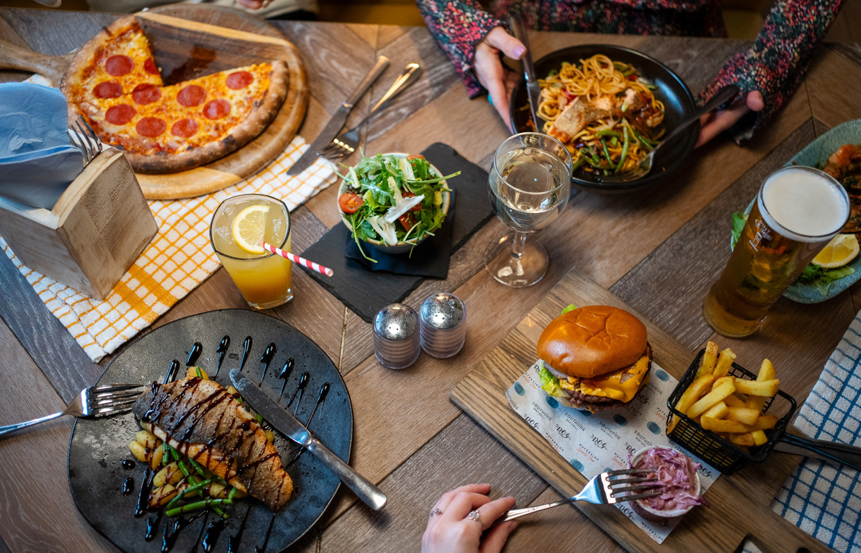 A selection of dishes from Breeze Bar & Grill including pizza, fish, burger and noodle bowl