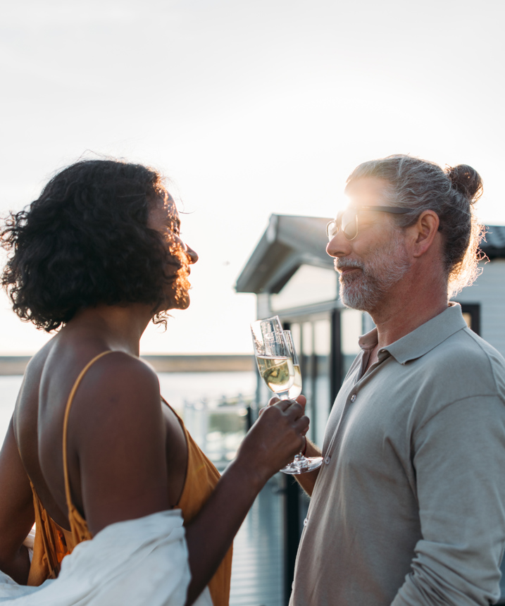 Couple celebrating on deck of holiday home overlooking chesil beach