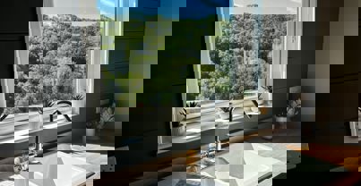 View of trees out of kitchen window by kitchen sink