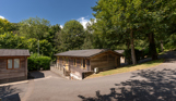 A secluded road on a lodge park with trees and lodges on a sunny, blue sky day