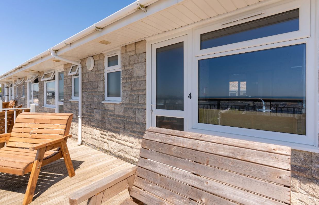 Front door of Chesil Beach apartments with outdoor furniture on the balcony