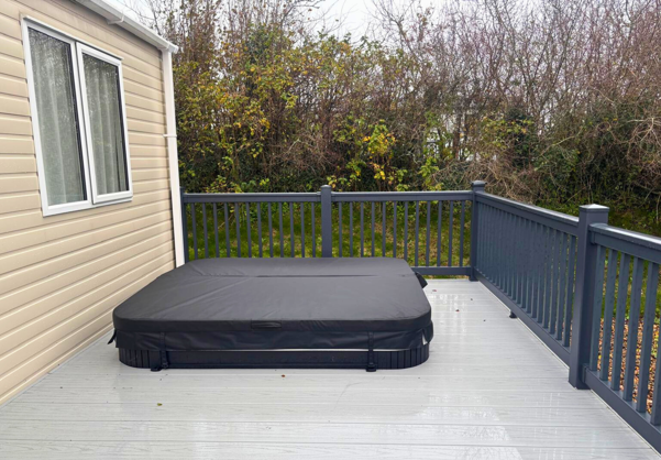 External of a caravan with decking and hot tub