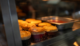 A selection of pies on a hot plate in a fish and chip shop