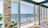 Views out to sea from Drift Bar & Grill's seating area through wide open french doors on a sunny, blue sky day