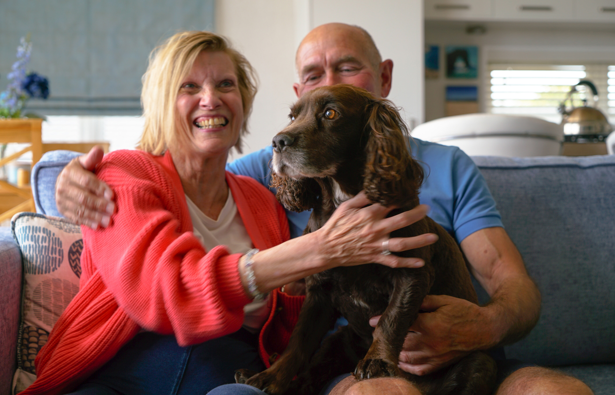 Osmington Owners cuddling dog on sofa