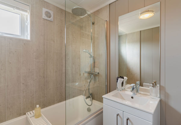 Internal of a luxury lodge bathroom with sink and shower over bath