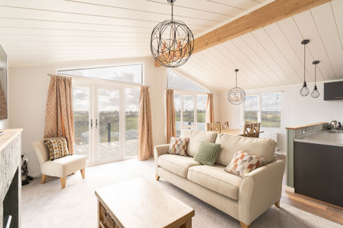 lounge area with sofa armchair and coffee table with large windows and patio doors
