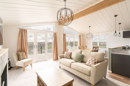 lounge area with sofa armchair and coffee table with large windows and patio doors