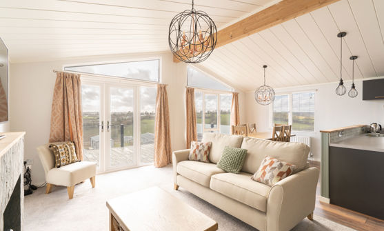 lounge area with sofa armchair and coffee table with large windows and patio doors