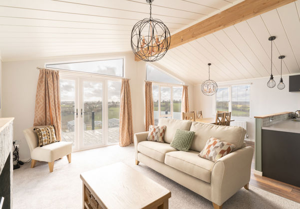 lounge area with sofa armchair and coffee table with large windows and patio doors