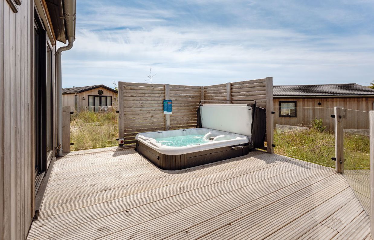 External of a luxury lodge with decking and hot tub