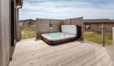 External of a luxury lodge with decking and hot tub
