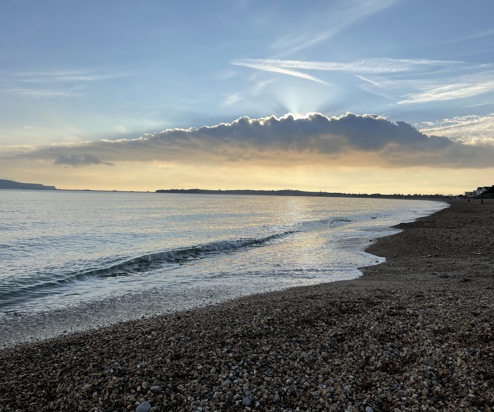 Bowleaze Cove Beach at sunset with dramatic clouds and calm waters