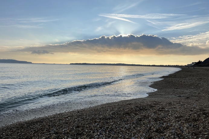 Bowleaze Cove Beach at sunset with dramatic clouds and calm waters