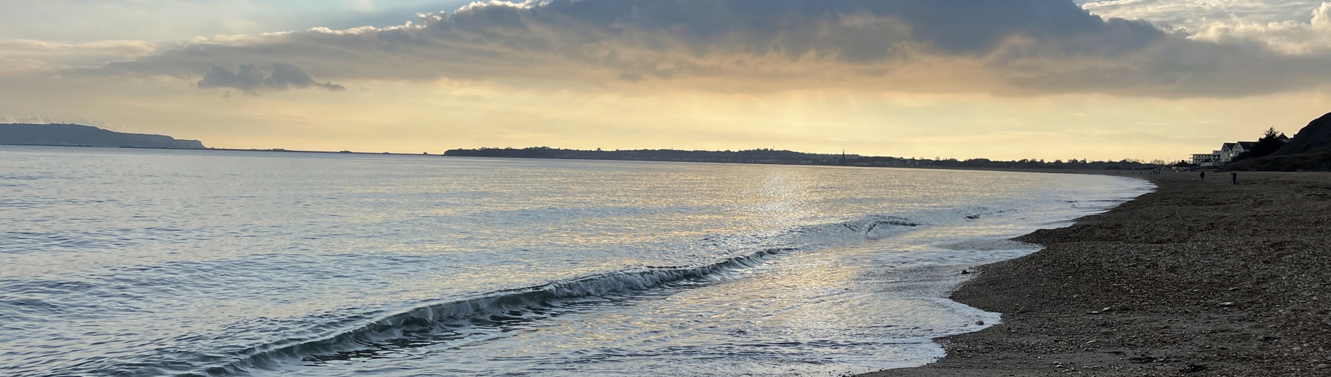 Bowleaze Cove Beach at sunset with dramatic clouds and calm waters