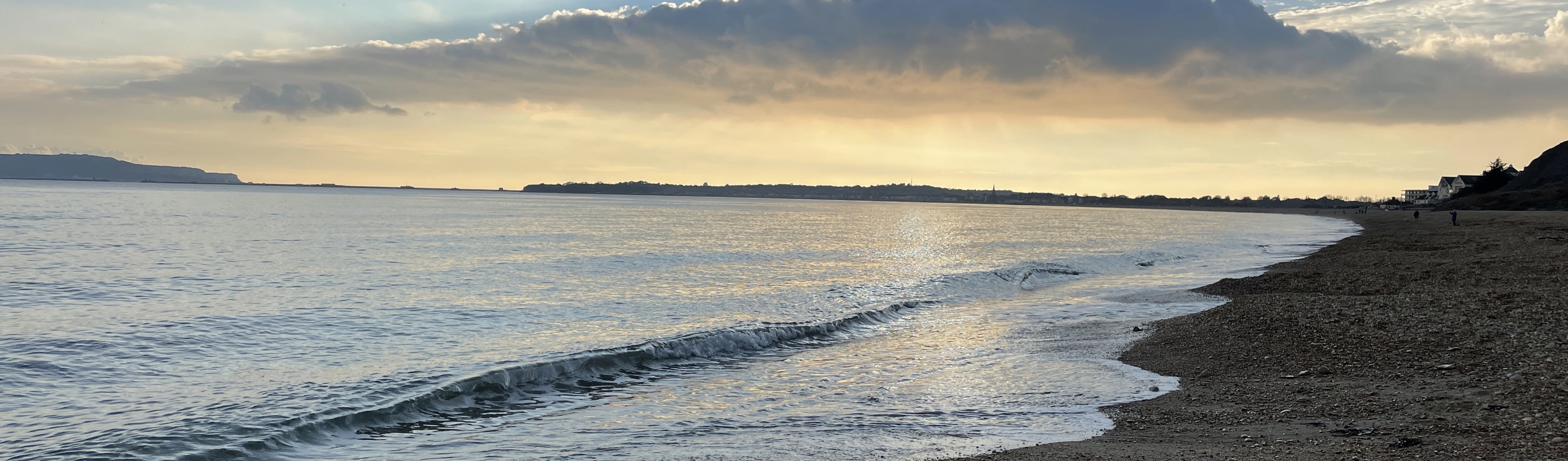 Bowleaze Cove Beach at sunset with dramatic clouds and calm waters