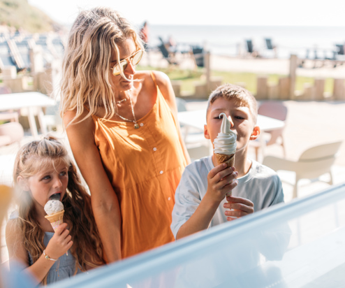 A woman with two young children at an ice cream parlour