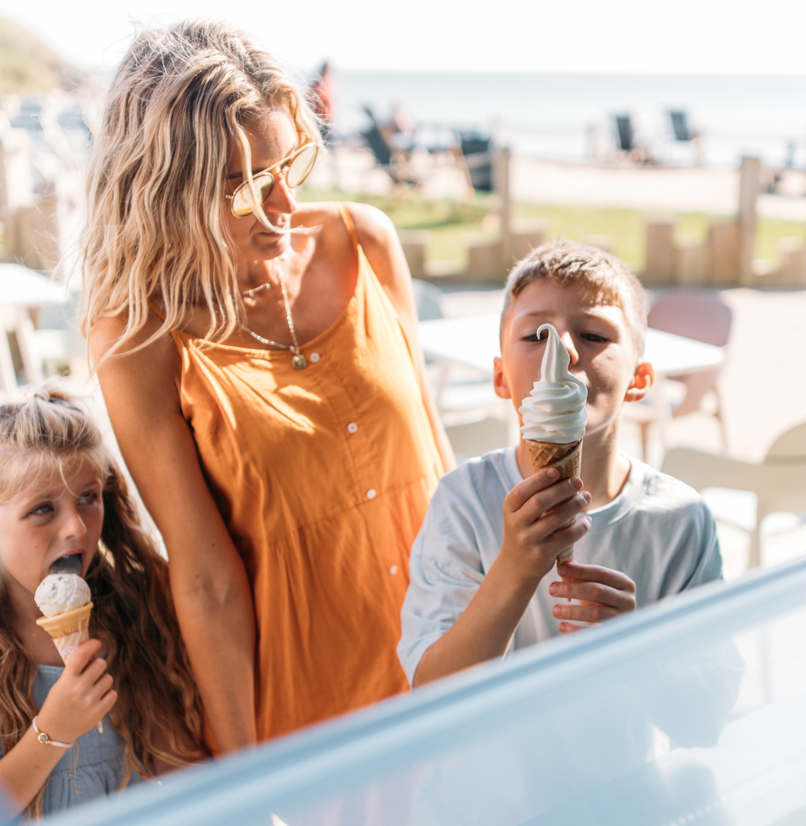 A woman with two young children at an ice cream parlour