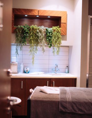 A spa treatment room with shower, bed, products and cosy, calming decór