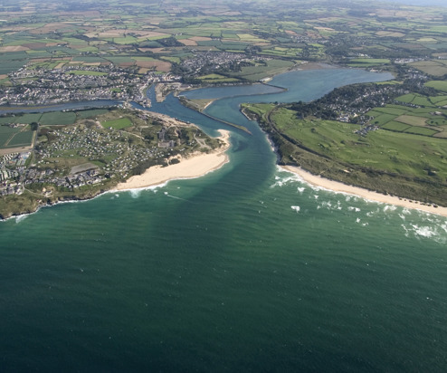 A bird's eye view of a coastal town with beaches and surrounding countryside