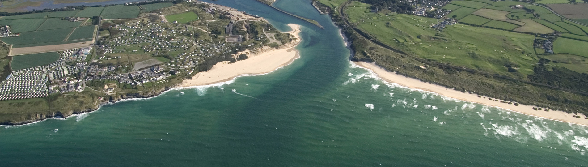 A bird's eye view of a coastal town with beaches and surrounding countryside