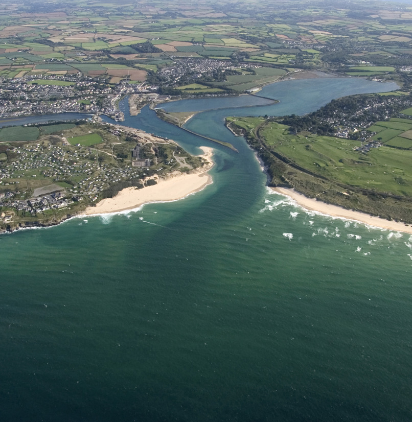 A bird's eye view of a coastal town with beaches and surrounding countryside