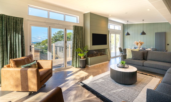 Cosy and contemporary lounge with large L-shaped sofa, armchairs, and fireplace