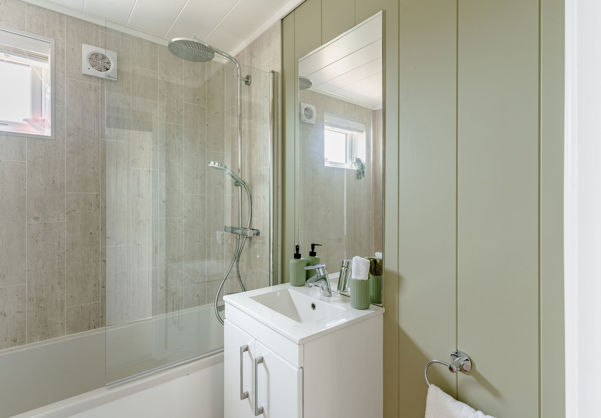 Internal of a luxury lodge bathroom with sink and shower over bath