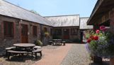 External of a cottage courtyard area with outdoor benches and flowers