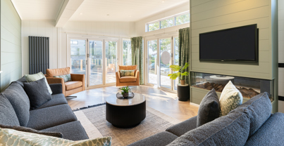 Bright and spacious lounge looking towards glass fronted bi-fold doors leading out onto large decking area