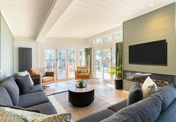Bright and spacious lounge looking towards glass fronted bi-fold doors leading out onto large decking area