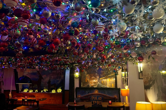 A pub at christmas time with a ceiling filled with baubles