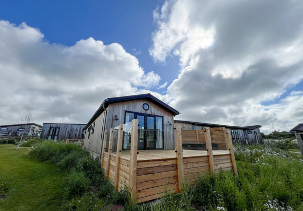 External of a luxury lodge on pitch with decking 