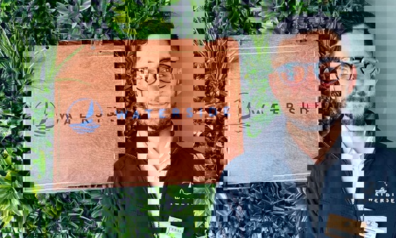 A smiling man stood beside a Waterside sign