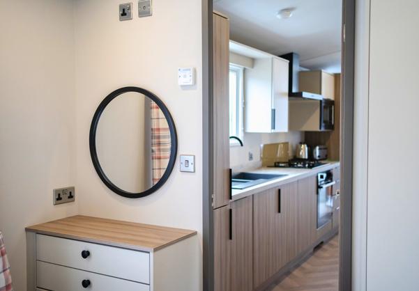 Internal of a caravan double bedroom with dressing area adjacent to kitchen