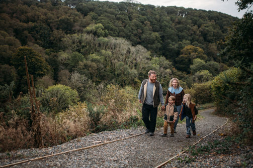 A family of four walking along a nature path among woodland 