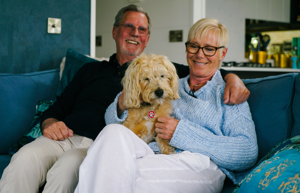 Stables Owners smiling with dog on sofa
