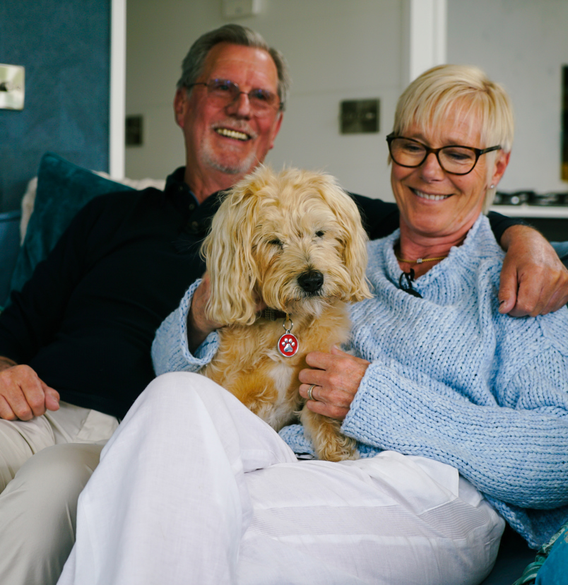 Stables Owners smiling with dog on sofa